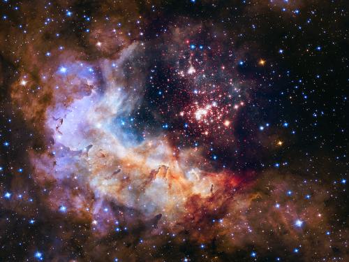 A nebula of dust and gases with orange, red, and pink clouds visible. Several blue and red starts are also visible.