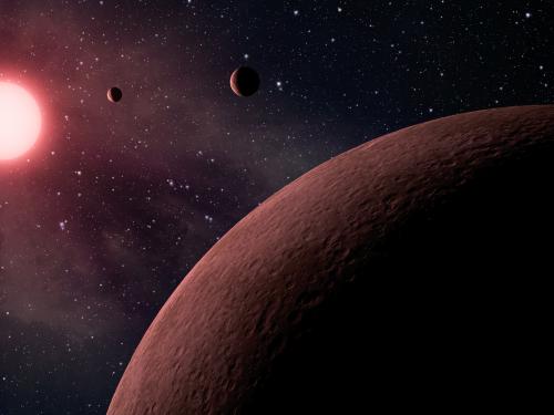 Depiction of three small terrestial planets in orbit close to a star in a far away solar system.