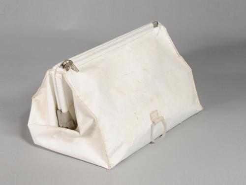 White cloth stowage bag used during Apollo 11 mission. Bag has one zipper entry at the top of the bag.