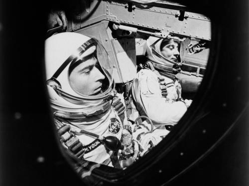 This view of astronauts John W. Young (left), pilot, and Virgil I. Grissom, command pilot, was taken through the window of the open hatch on Young's side of the Gemini-Titan 3 spacecraft just before the hatches were closed in readiness for their three-orb
