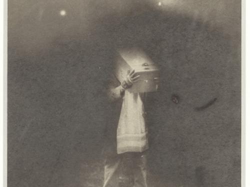 Black and white artistic photo of someone with a box over their head. 