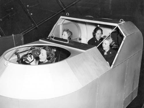 Four women sit within a simulator.