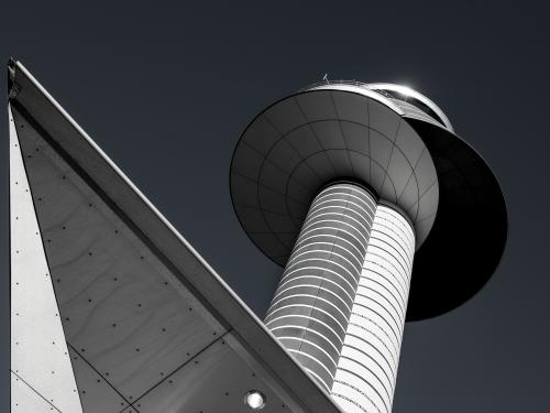 Lower view of an air traffic control tower with a double cylinder-shaped base with two circular sections combined atop the base.