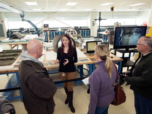 A Museum conservation specialist speaks to three visitors as part of a tour of the Museum's conservation laboratory.