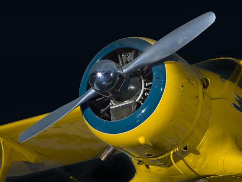 Closeup view of the two-blade propeller and engine from yellow Beechcraft C17L Staggerwing aircraft