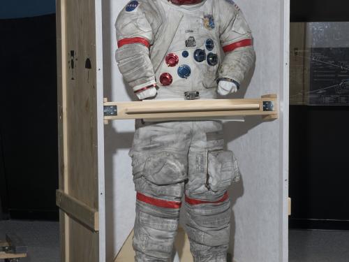 Gene Cernan's Apollo 17 spacesuit being moved out of the exhibit case in the "Apollo to Moon" gallery 