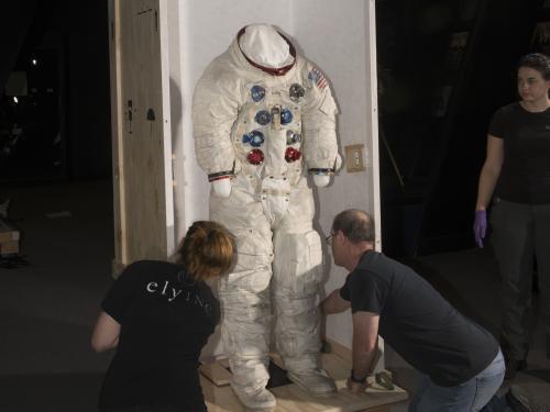 Buzz Aldrin's Apollo 11 spacesuit being moved out of the exhibit case in the "Apollo to Moon" gallery 