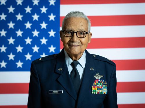 Man in military uniform in front of American flag