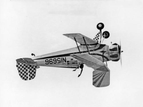 Black and white photo of the aircraft with pilot's hands in the air. 