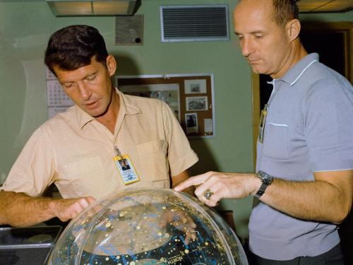 Astronauts Wally Schirra and Thomas Stafford, examine a star globe ahead of their upcoming Gemini VI mission