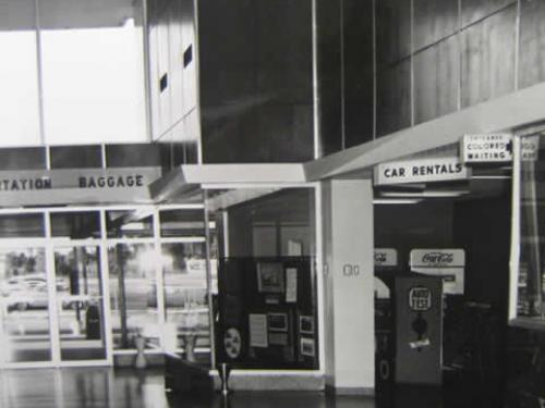 Image of the airport waiting room that shows a sign on right to a sitting area for African Americans.