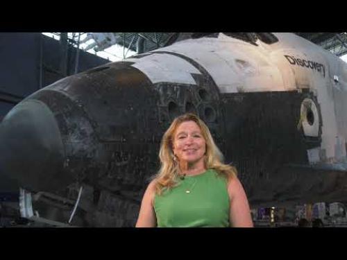 Director Ellen Stofan stands in front of the Space Shuttle Discovery at the Udvar-Hazy Center