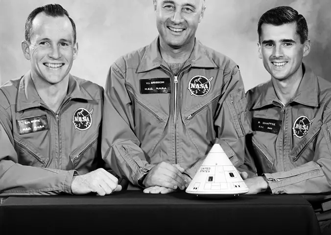 Three men smile at the camera.