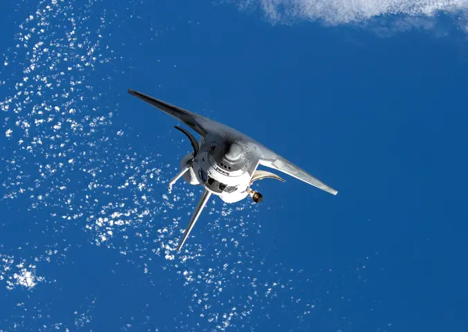 Inverted Space Shuttle Discovery orbits Earth