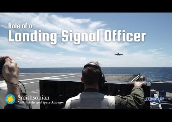 An interview with a landing signal officer including B-roll of an aircraft carrier and animation.