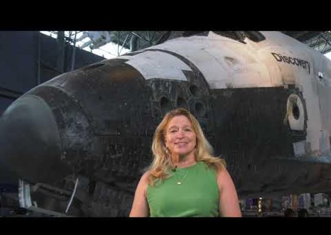 Director Ellen Stofan stands in front of the Space Shuttle Discovery at the Udvar-Hazy Center
