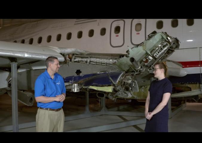 Interview with museum curator in front of airplane. 