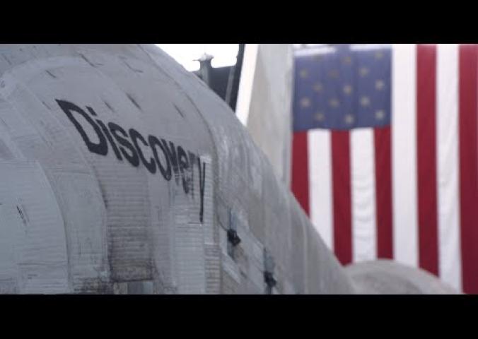 A video of a woman walking through the inside of the space shuttle discovery pointing out areas of interest.