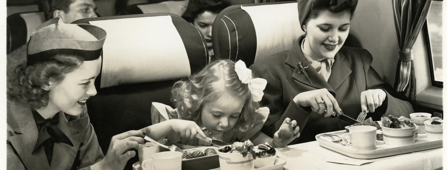 United Airlines flight attendant assisting passengers wearing the United Airlines flight attendant cap (1946)