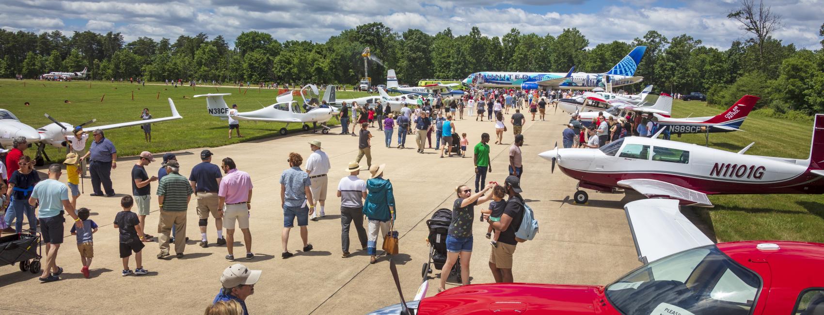 People admire planes parked outside the Museum. The planes taxied over from Dulles Airport. There are a variety of planes, large and small. 