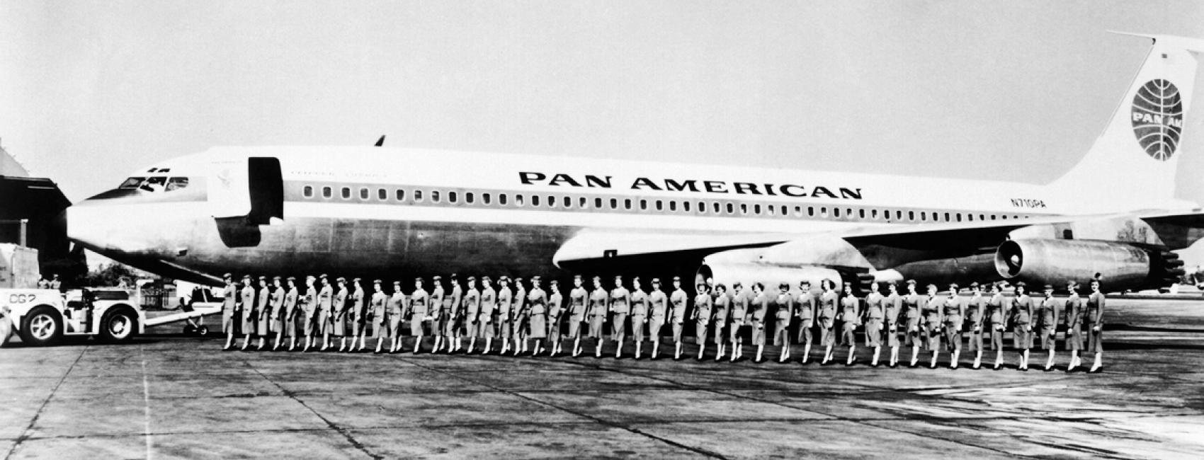 A group of Pan American Airways flight attendants board a commercial jet in a straight line.