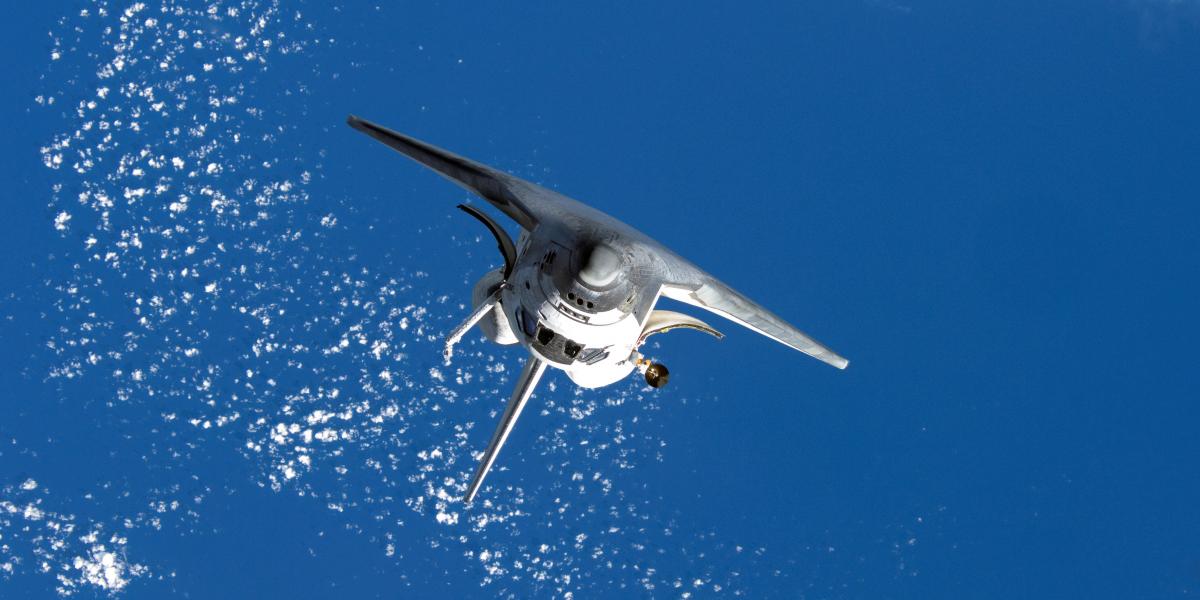 Inverted Space Shuttle Discovery orbits Earth