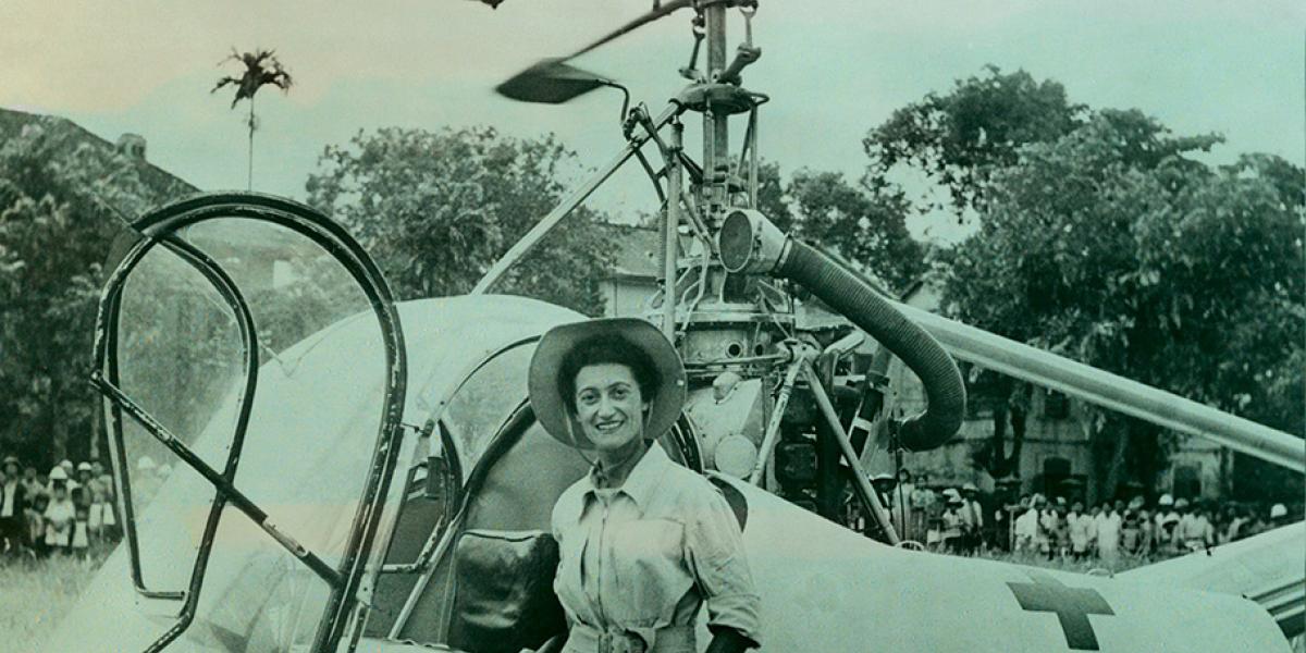 Doctor Valerie Andre in front of her helicopter with jungle in background