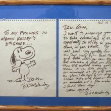 A framed letter with a drawing of Snoopy.