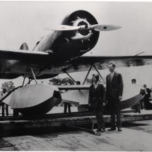 Two people standing in front of an aircraft