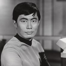 A man in a Star Trek uniform stares at the camera.