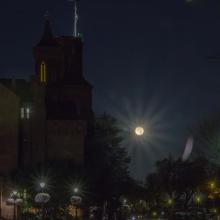 The moon rising with the Smithsonian Castle on the left hand side. 