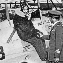 A woman sitting on top of an airplane shakes a man's hand. 