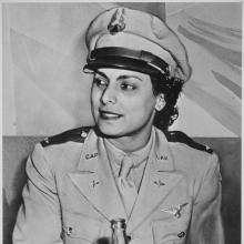 A woman in CAP uniform sits drinking a Coke.