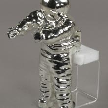 A photo of a silver-colored statue that is shaped like an astronaut. 