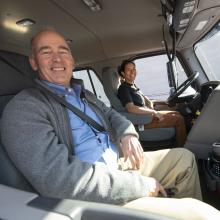 Two people in a truck smiling and posing for a picture.