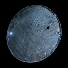 Underside view of a space capsule. The background of the image is black. 