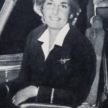 A woman in a captain's outfit smiles at the camera.