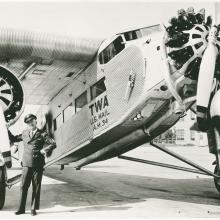 Transcontinental and Western Air Pilot Arthur Burns standing in front of a Ford 5-AT Tri-Motor