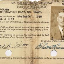 Card, ripped at the top with two holes punched in the bottom.  Text at top: United States Department of Commerce, Civil Aeronautics Authority. Small vertical photo in the upper right hand corner: White man with medium colored tousled hair wearing a suit and tie. Two signatures at the bottom: (left) Michael A. Gitt (Right) Robert K. Reining