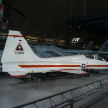 Rear view of a white and orange painted airplane in the museum hangar. 