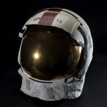 A helmet with a reflective face shield and Apollo 15 written across the visor. 