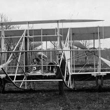 Front of a wright airplane on the ground.