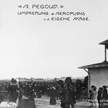 A crowd watching an airplane do a loop in the air. Text on the photo says "A. Pegoud, Umdrehung d. Aeroplans, u.d. Eigene Achse"