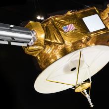 A model of New Horizons spacecraft against a black backdrop.