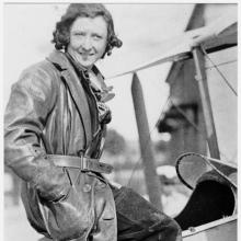 Black and white image of Maude Rose Rubens "Lores" Bonney sitting at the top of an aircraft.