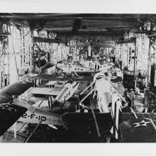 Black and white grainy image of numerous aircraft stored on a aircraft carrier