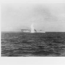 Black and white grainy image of the USS Langley under attack