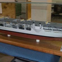 A model of an aircraft carrier inside clear case.