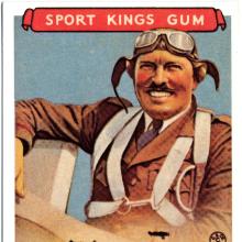 Trading card featuring an illustrated smiling aviator wearing a flying suit, cap, and goggles. The top of the card says Sports King Gum and the bottom says Col. Roscoe Turner.