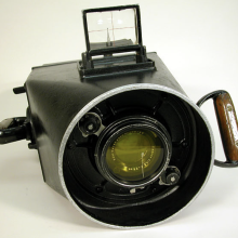 A black camera that is largely one large circular lens. 